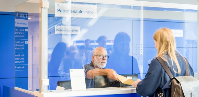 Patienten am Empfangstresen bei der Aufnahme