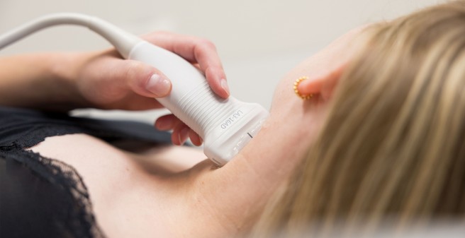 Schilddrüse einer Patienten wird mittels Ultraschall untersucht