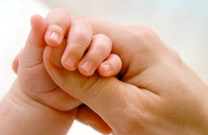 Mother holding babys hand