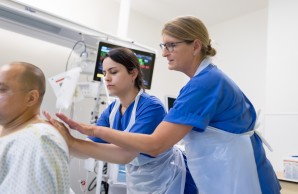 Anleitungssituation zwei Pflegende mit einem Patienten