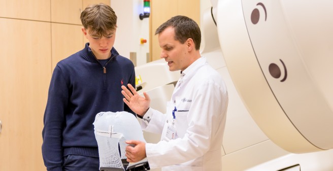 Priv.-Doz. Dr. David Krug zeigt Piet den Schwenkkopf des Linearbeschleunigers