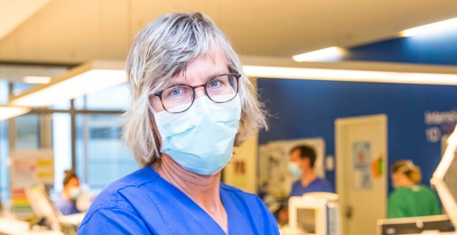 Claudia Wekker mit Atemschutzmaske blickt in die Kamera