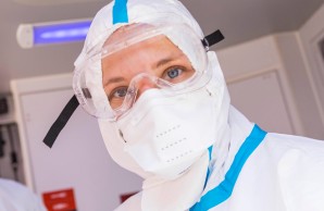 Stefanie Beck mit ihrem Kollegen, dem Notfallsanitäter Sebastian Götsch, in voller Sicherheitsausrüstung blicken aus dem Inneren des Rettungswagens in die Kamera