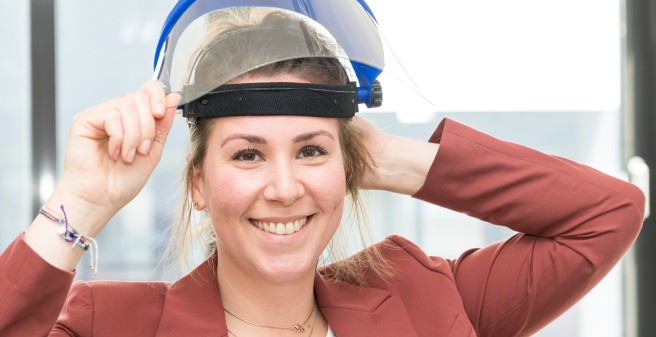 Janna-Lynn Schrödesetzt eine Gesichtsschutzmaske auf, sie lächelt strahlend in die Kamera