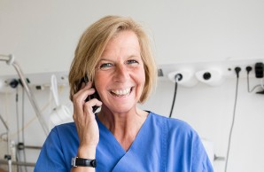 Petra Sauer mit Telefon am Ohr lächelt in die Kamera
