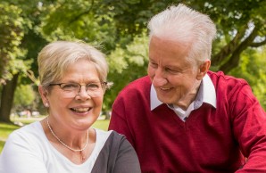 Peter Seifert und Frau sitzen im Grünen, er lächelt sie an, Frau Seifert lächelt in die Kamera. Ein Sommertag