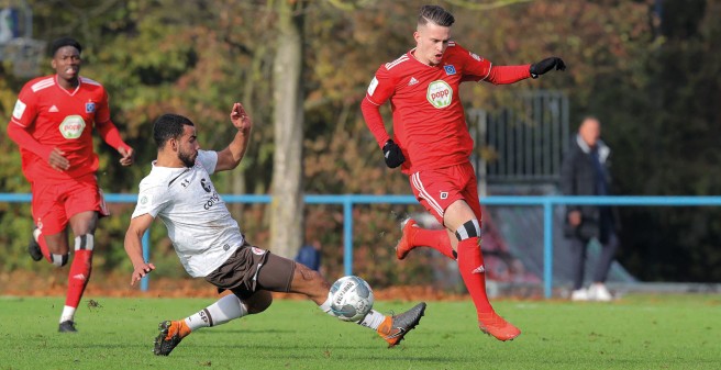 Zwei Spieler aus der U19 des HSV im rasanten Kampf um den Ball. Einer rennt mit dem Ball am Fuß, der andere versucht reinzugrätschen