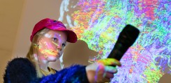 Johanna Klawonn mit Mikro in der Hand vor der Projektion eines bunt gefärbten Hirns