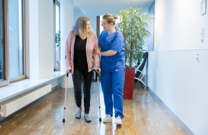 Eine Ärztin in Weiterbildung hilft einer Patientin bei der Mobilisation