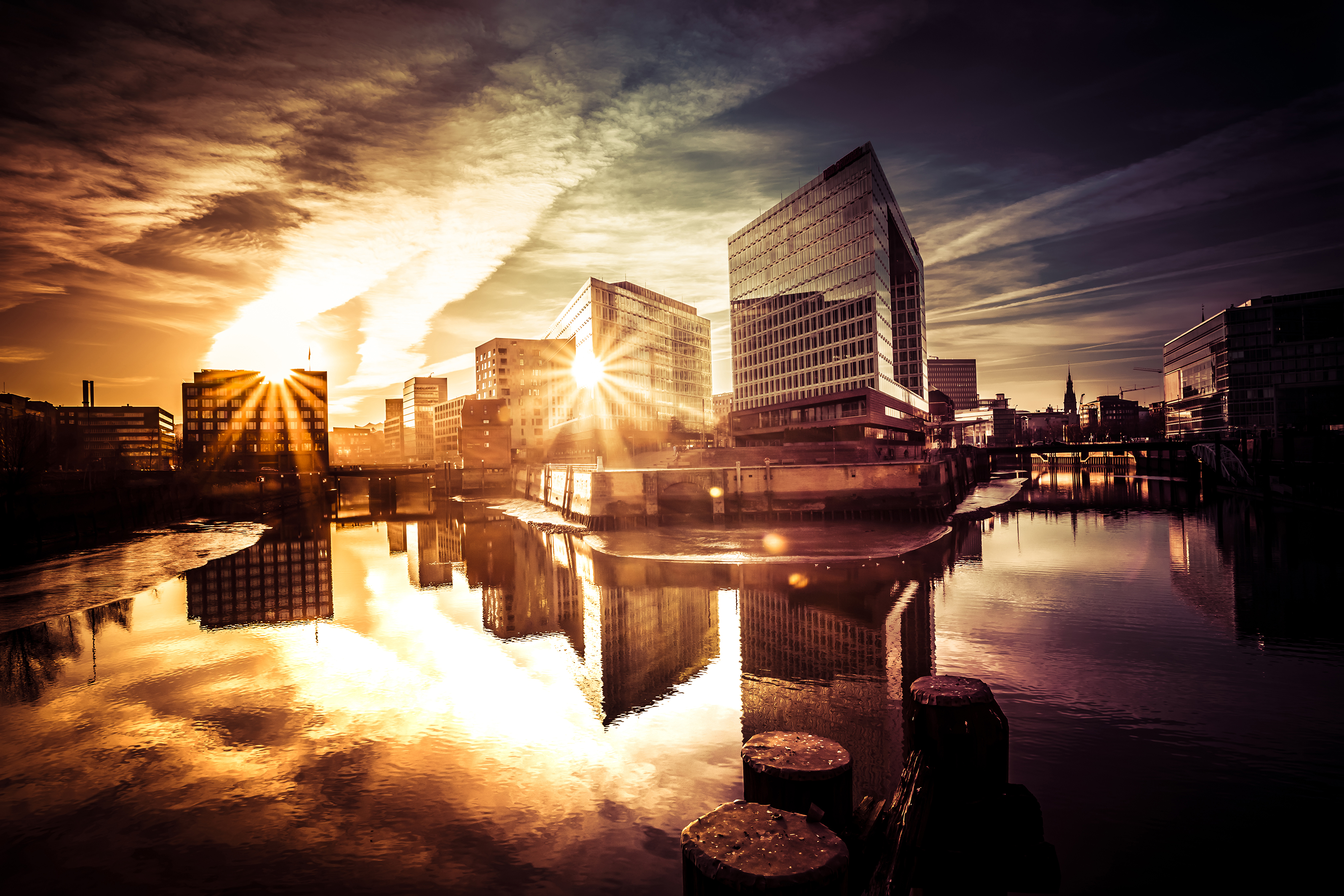  Coverbild des Magazins wissen+forschen 2026 mit einem Sonnenuntergang zwischen Gebäuden in der Hamburger Hafencity.