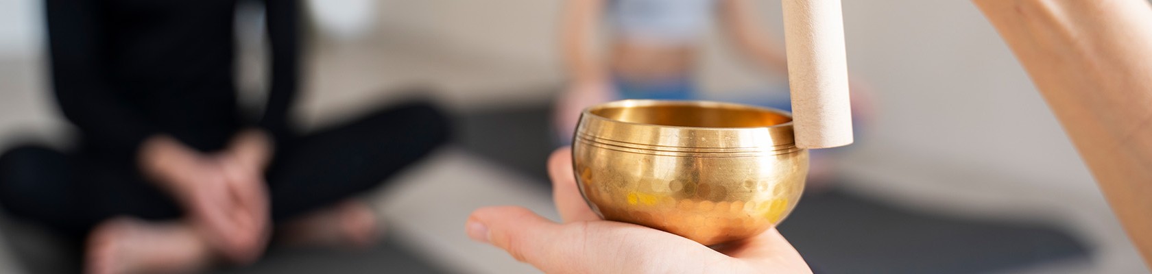In einem Meditationsraum wird eine Klangschale angeschlagen.