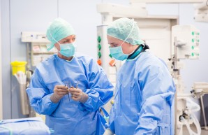 Ärztin zeigt Studentin im OP die Werkzeuge