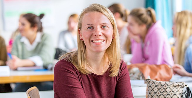  Lehrerin sitzt vor einer Klasse