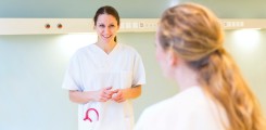 Gesundheits- und Kinderkrankenpflegerin tauscht sich mit einer Kollegin aus.