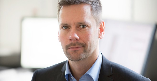 Mann vor Computerbildschirmen