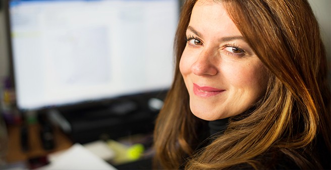 Lächelnde Frau vor Computerbildschirm